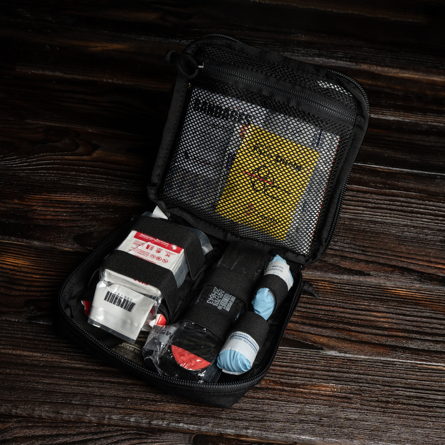 Compact first aid kit with bandages and gloves in a black case 