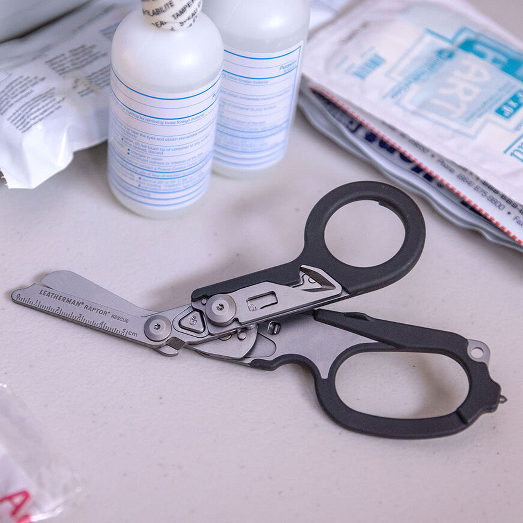 Scissors on a table with medical bottles and packages.